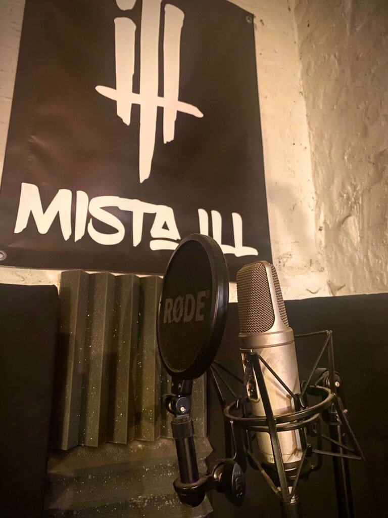 recording microphone in a home studio in front of Mista Ill poster