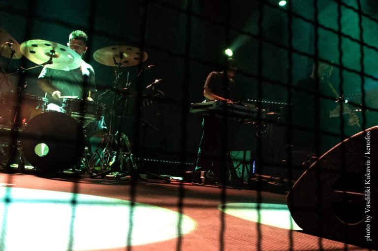 IOTA's keyboardist and drummer performing live on stage.