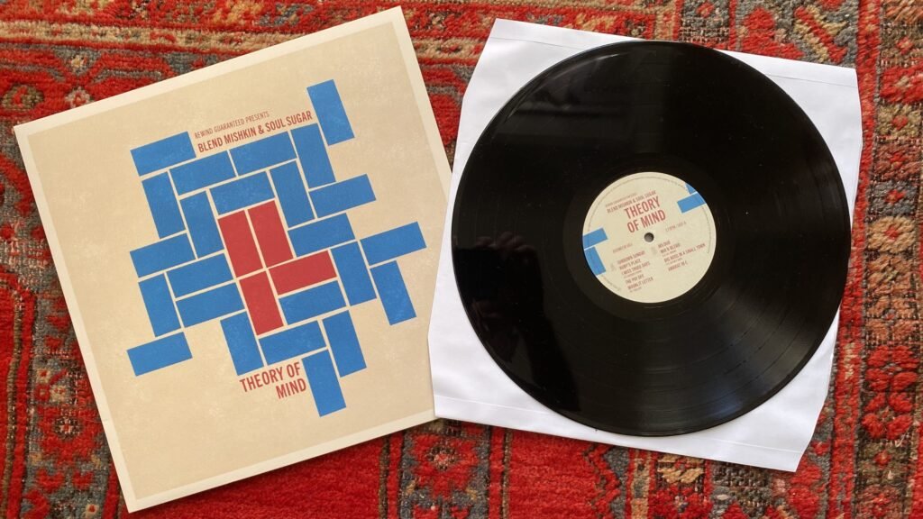 Black vinyl on white inner sleeve next to Theory of Mind album cover on a white background
