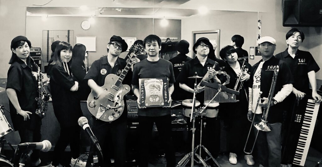 The Green Flyers band members holding instruments in studio with vinyl album