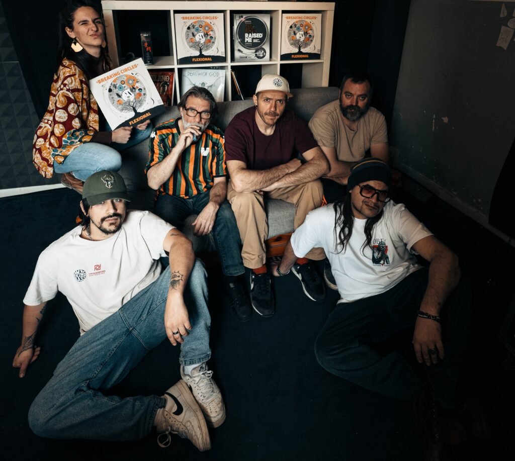 Flexional duo with musicians posing at record shelf, holding Breaking Circles vinyl