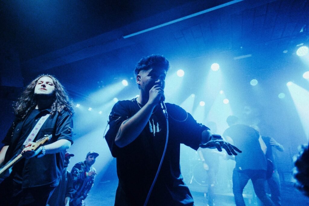 Outflow performing live under blue lights with singer and guitarist in focus