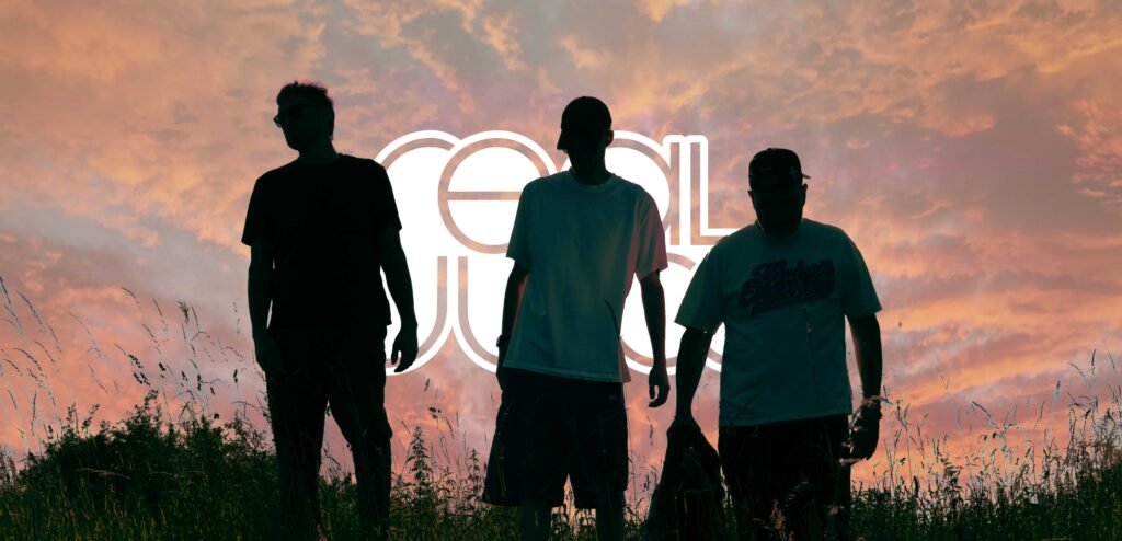 Real Juice band silhouettes walking through grass at sunset with logo in background