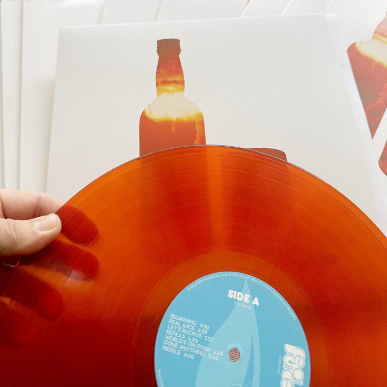 Close-up of Real Juice – Pimms & Beans translate orange vinyl record.